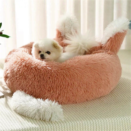 Small dog in a fluffy pink pet bed with white fur on a light background