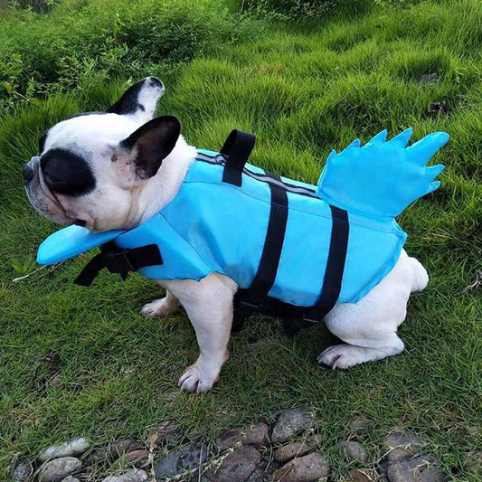 Blue shark-themed dog life vest with adjustable straps worn by a French Bulldog on grass